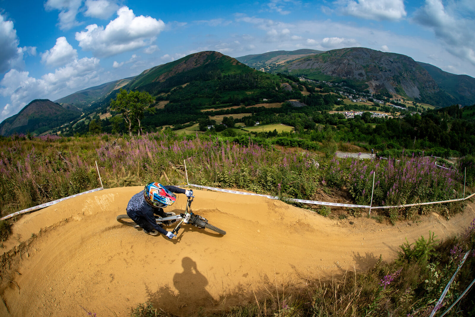 Rider cornering a berm with mountains behind