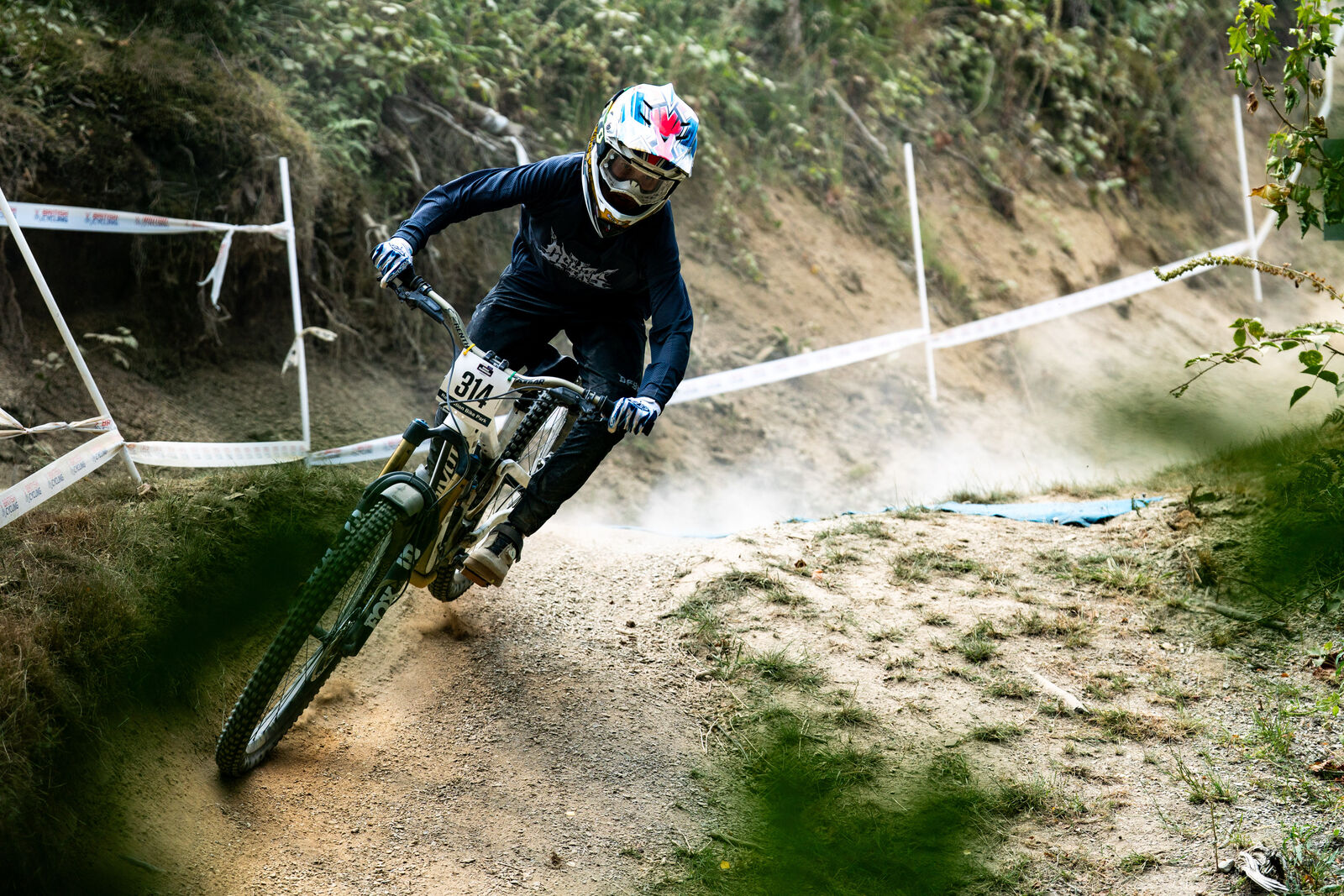 Stanlie Britt drifting a dusty downhill berm