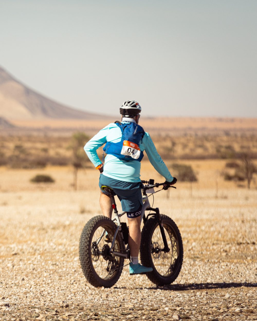 Tim Britt wearing race number 04 on a fat bike in the desert